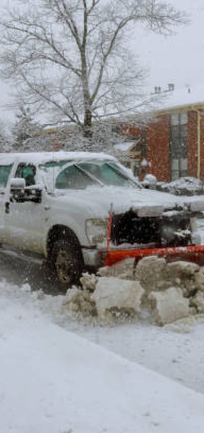 Snow plow removing snow from street. Snowplow trucks removing snow on the road street